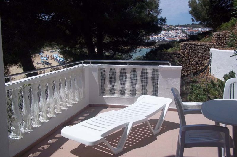 The terrace Jardín Playa 3 with sunbed for sunbathing in Menorca.