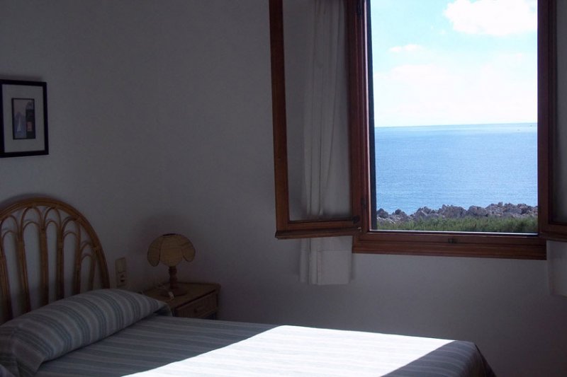 Habitació amb llit individual i bones vistes al mar de Menorca.
