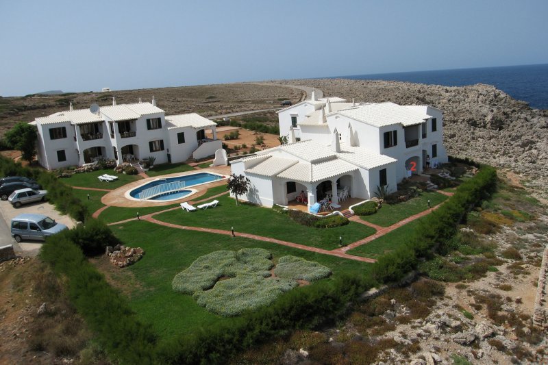 Vista de los apartamentos Rocas Marinas desde el aire, con la costa de Menorca de fondo.