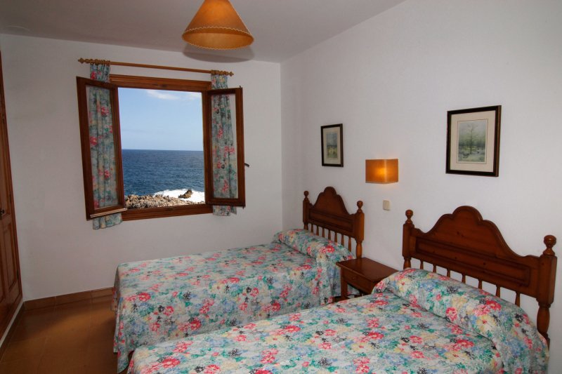 Habitació amb finestra i dos llits individuals de l'apartament Rocas Marinas 2R.