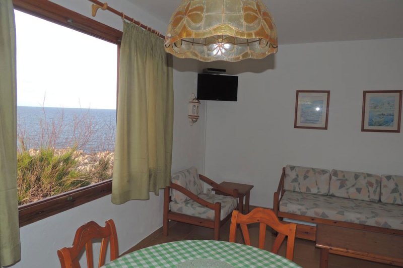 Saló menjador amb finestra al mar i la naturalesa de Menorca.