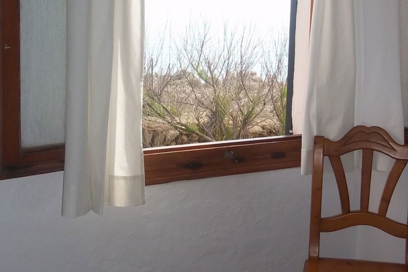 Finestra del dormitori principal amb vista a la costa de Menorca.