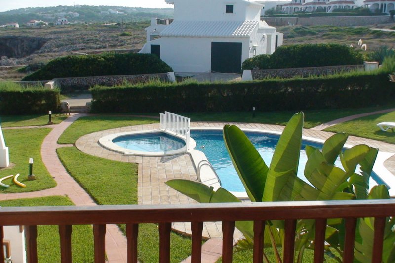 Vista desde el balcón del apartamento Rocas Marinas 5 hacia la piscina y el césped del recinto.