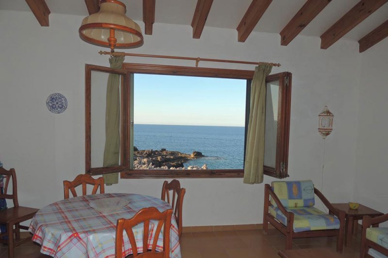 Ventana que da a la costa de Menorca desde los apartamentos Rocas Marinas.