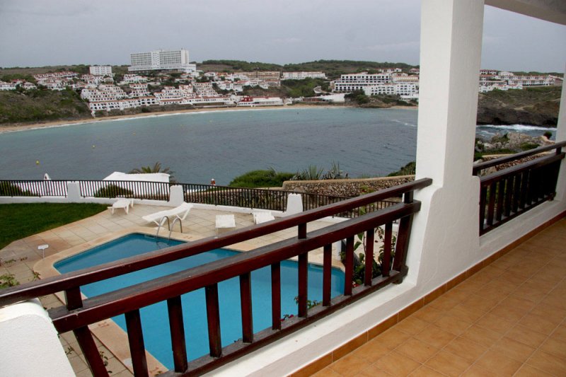 View to the pool of the Arco Iris apartments and the beach of s'Arenal d'en Castell, in Menorca.