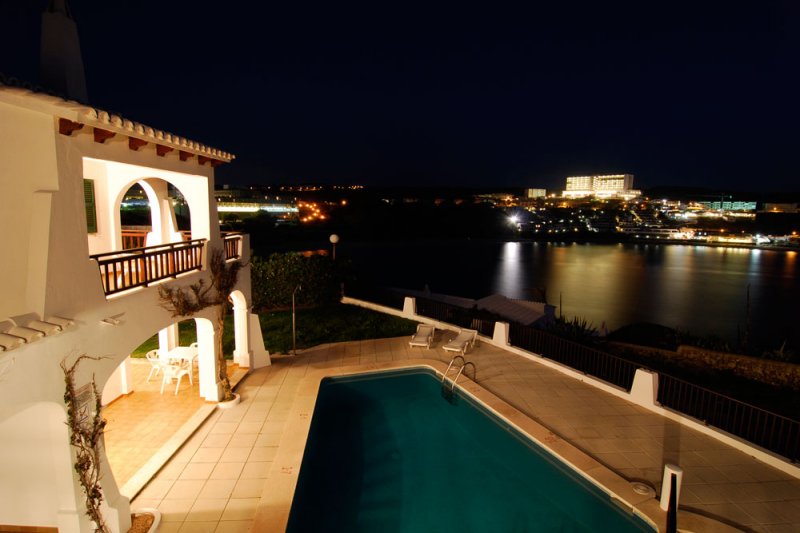Vista nocturna de los apartamentos Arco Iris en Menorca y s'Arenal d'en Castell de fondo.