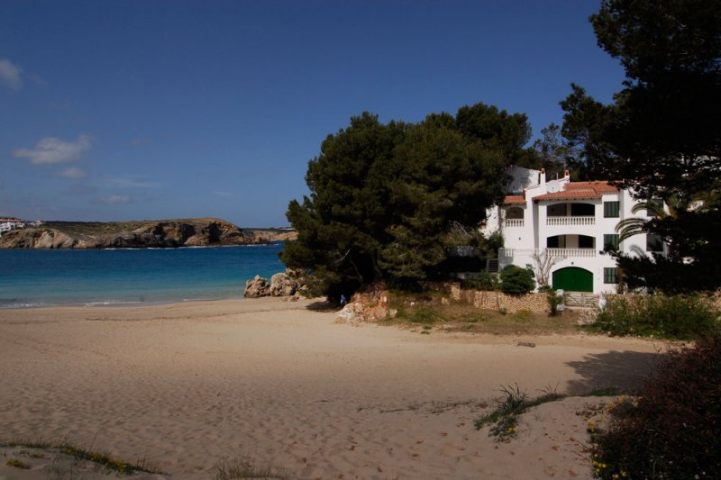 Vista de los apartamentos Jardín Playa desde la arena de s'Arenal d'en Castell y la costa de Menorca