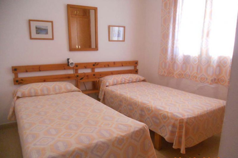 Dormitori amb dos llits individuals de l'apartament Jardín Playa 3.