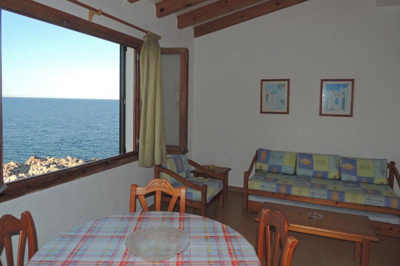 Ventanal del salón que da a la costa de Menorca. Vista desde el apartamento Rocas Marinas 5.