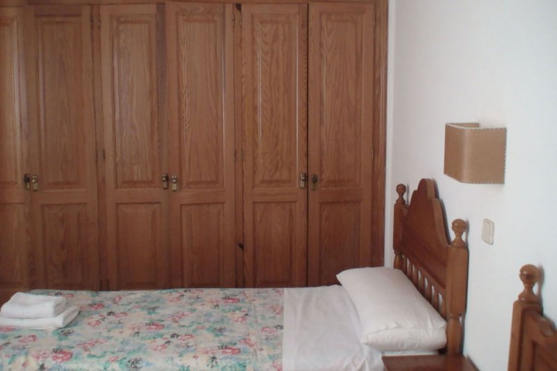 Bedroom with wardrobes and single beds of the Rocas Marinas 5 apartment.